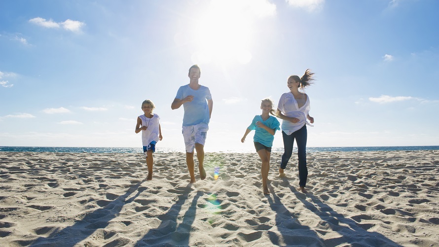 Familie am Strand. Eine Familie läuft über den Sandstrand.